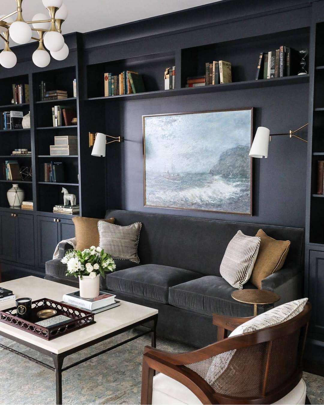Un coin canapé bleu foncé avec étagères intégrées dans un salon.