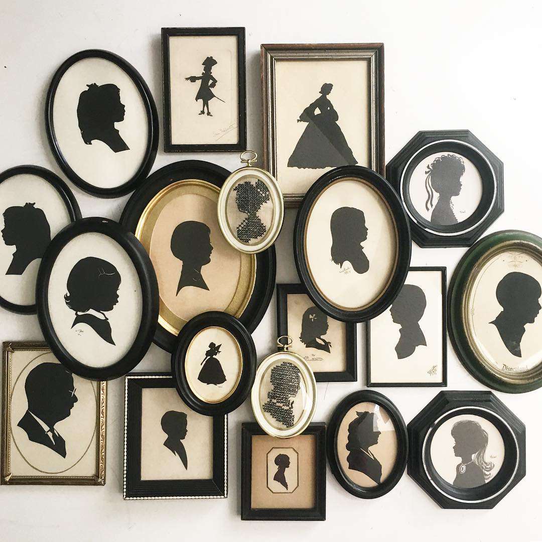 Set of overlapping picture frames with black portrait silhouettes