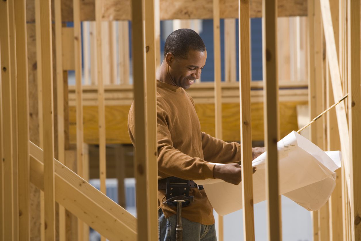 Un obrero de la construcción enmarcando una casa