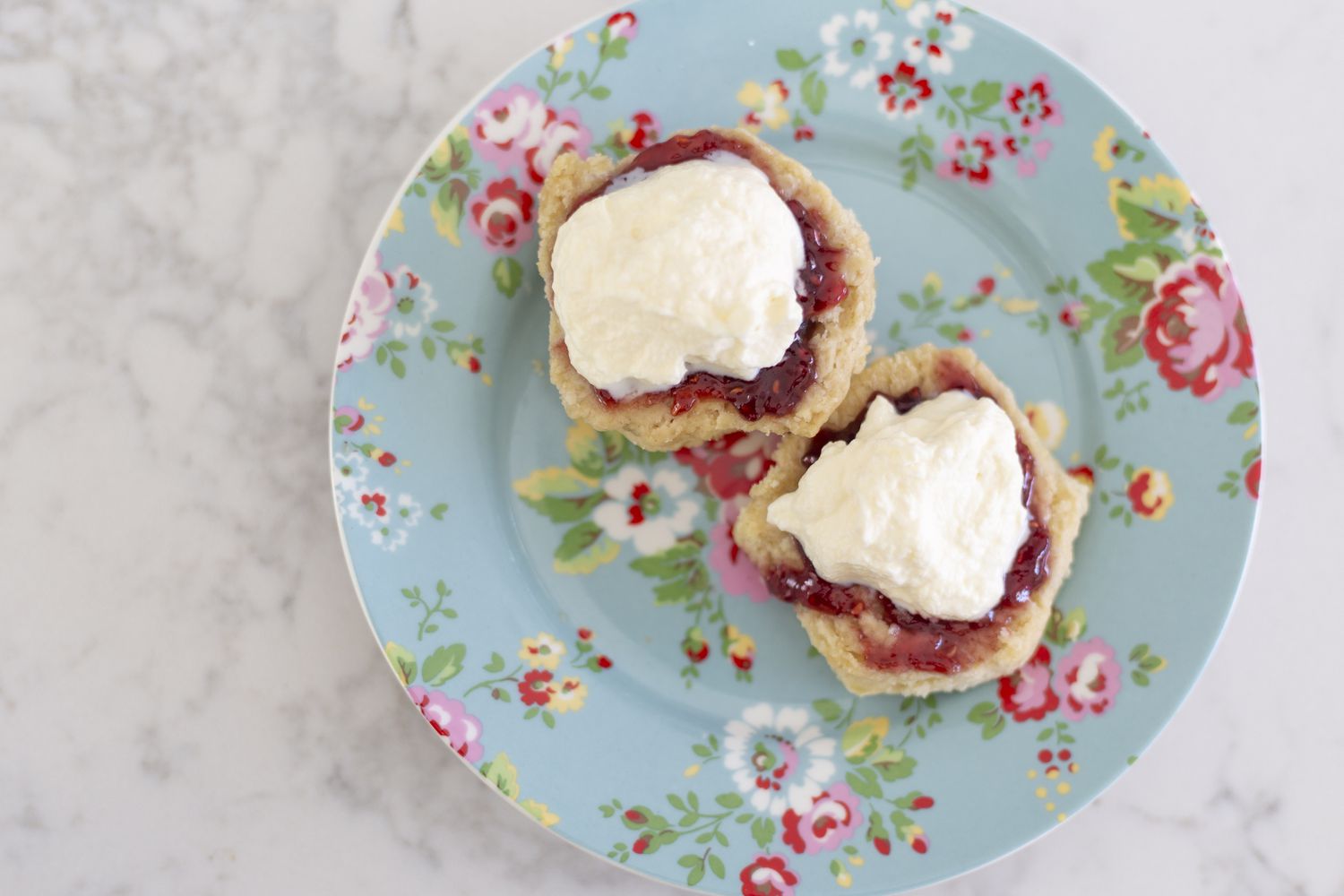 Buttercreme und Marmelade auf Scones