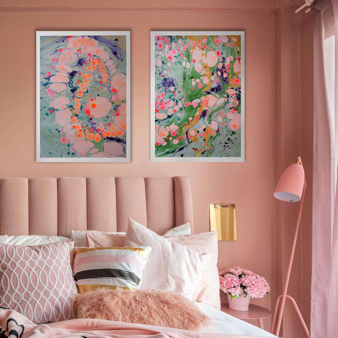 Schlafzimmer mit pfirsichfarbenen Wänden und abstrakten Bildern