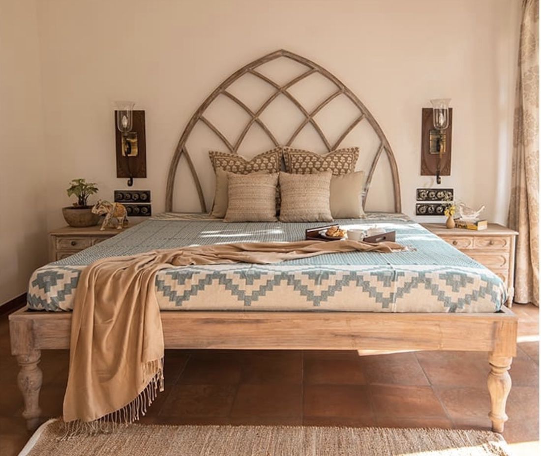 quarto mediterrâneo com piso de terracota, arandelas de madeira, colcha de padrão azul