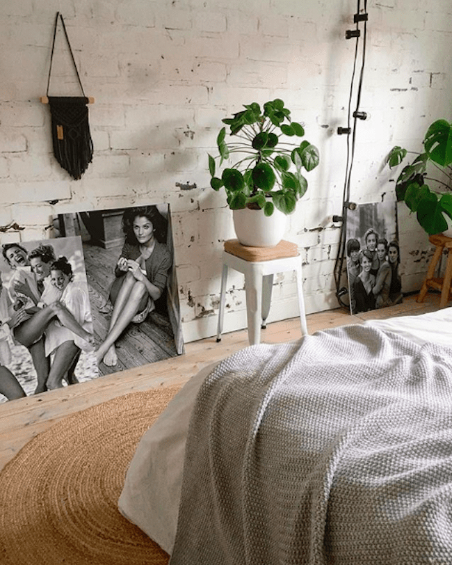 Schlafzimmer mit weißer Ziegelwand und großen schwarz-weißen Bildern
