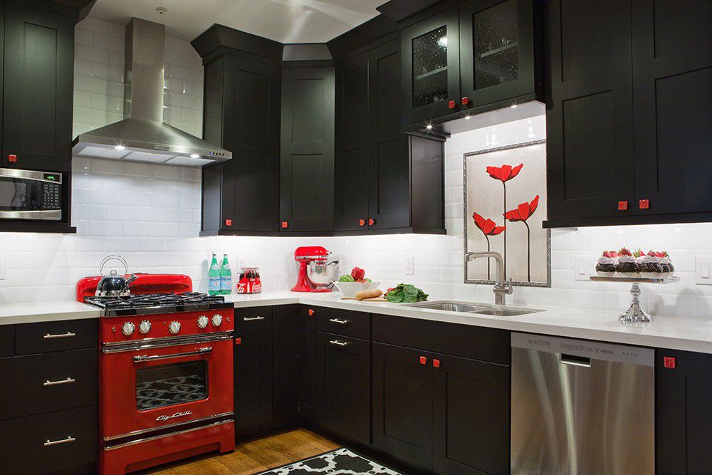 Cocina retro negra con detalles y herrajes rojos y electrodomésticos de acero inoxidable