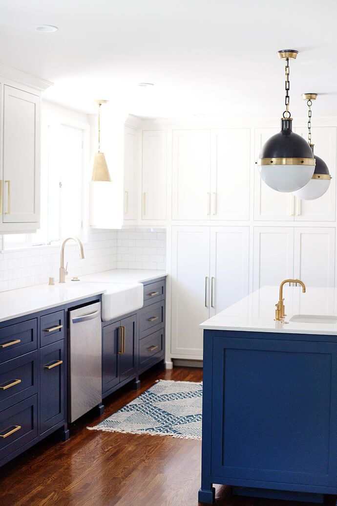 Uma cozinha em dois tons de azul e branco com piso de madeira