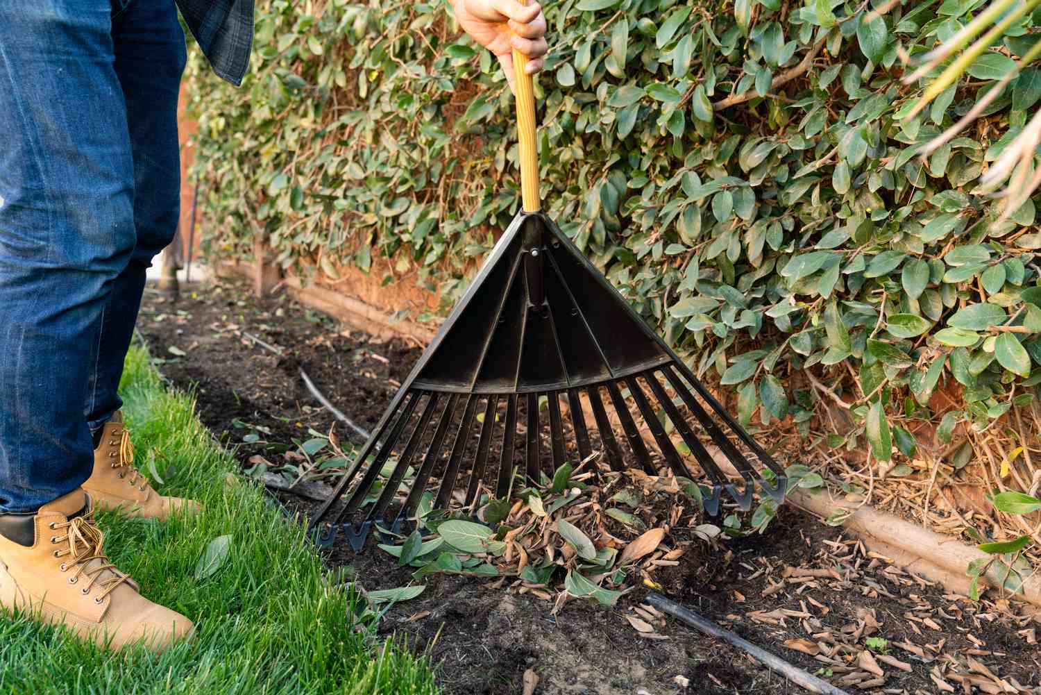 Person mit einer Gartenharke