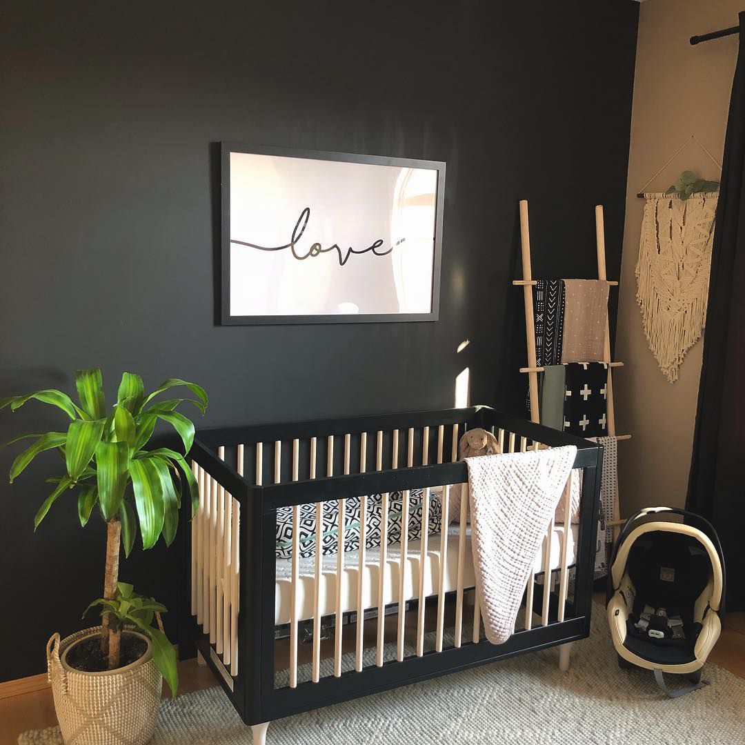 Quarto de bebê Boho com parede preta de destaque