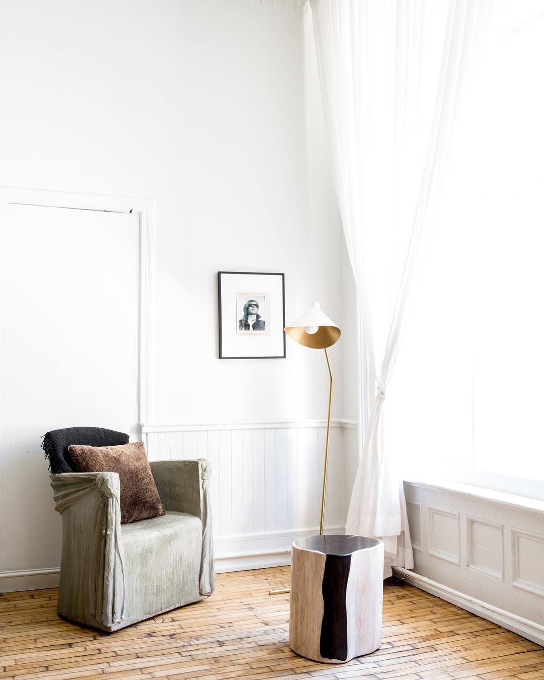 Cadeira pequena, mesa de centro e luminária de chão no canto da sala