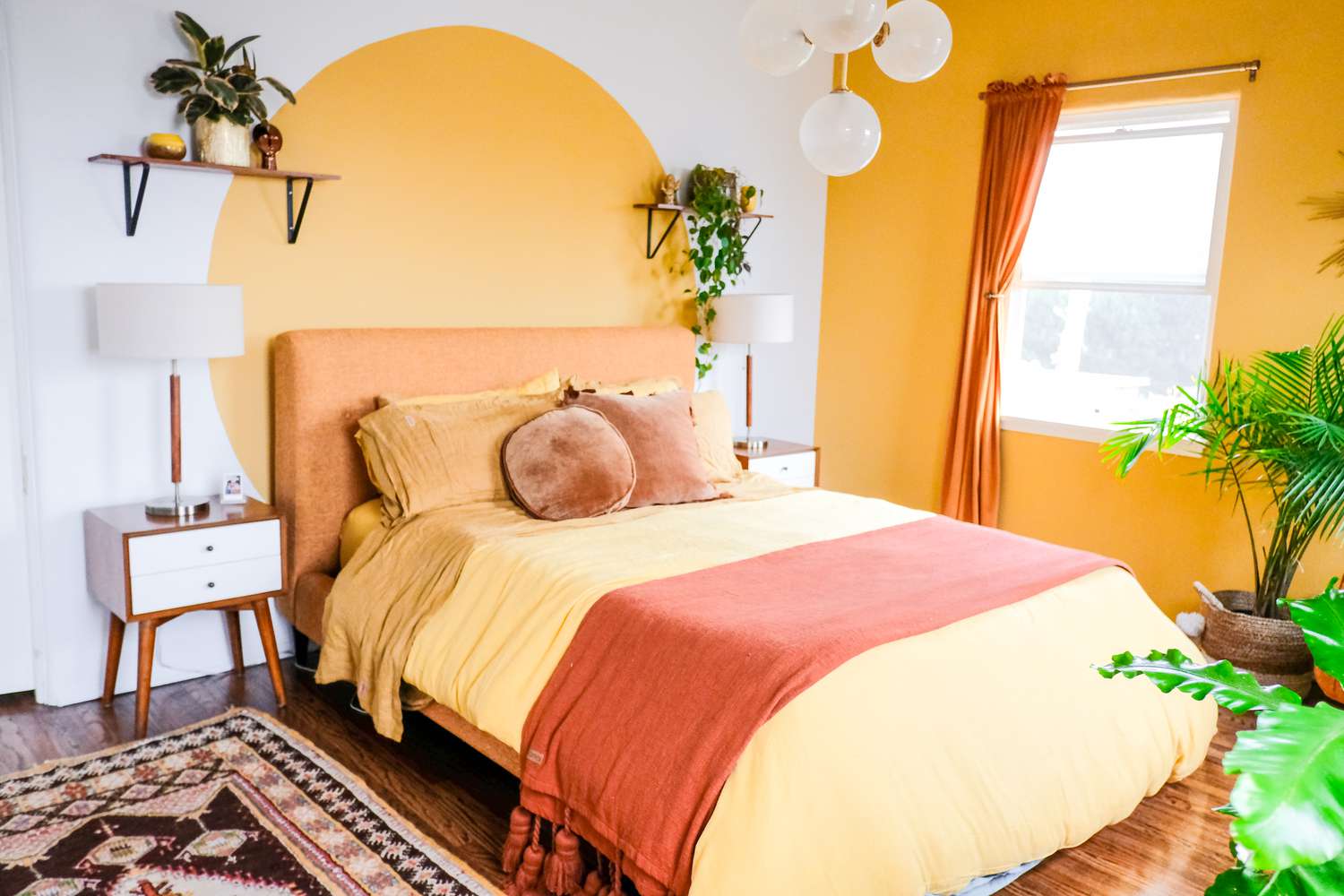 Schlafzimmer mit leuchtend gelber Akzentwand und farblich abgestimmtem gelben Kreis hinter dem Bett.
