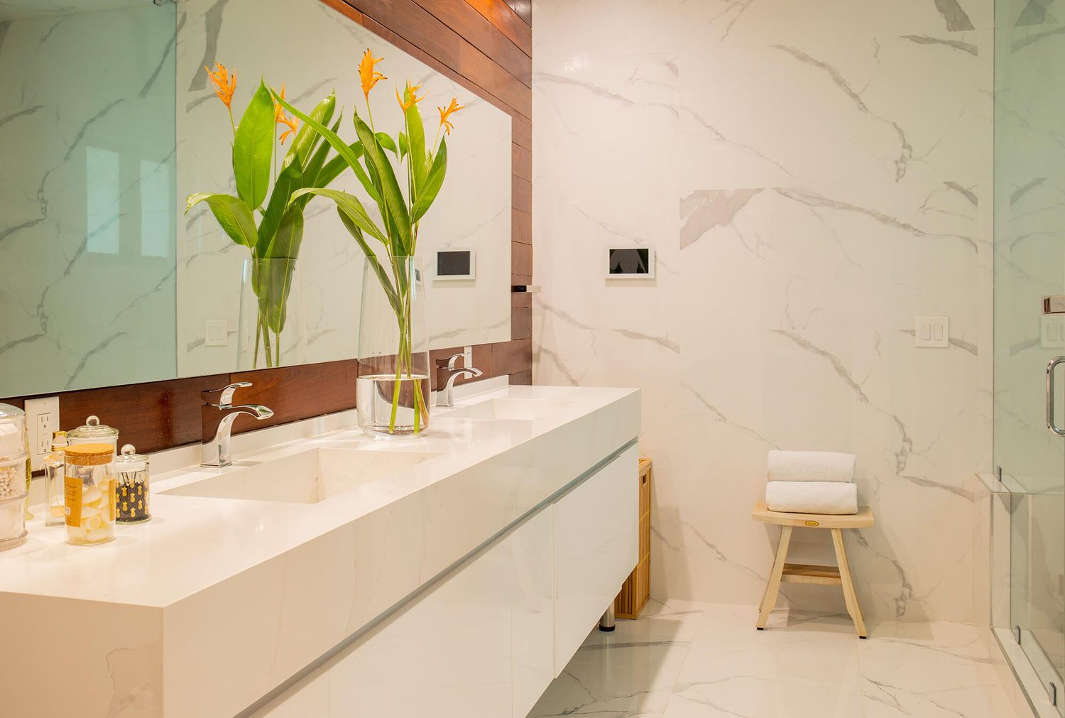 marble bathroom with wood paneling behind vanity