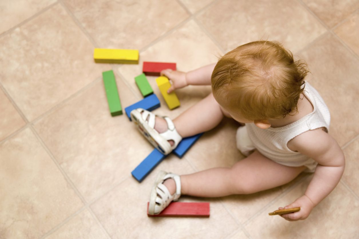 Linoleumboden im Spielzimmer mit spielendem Kleinkind
