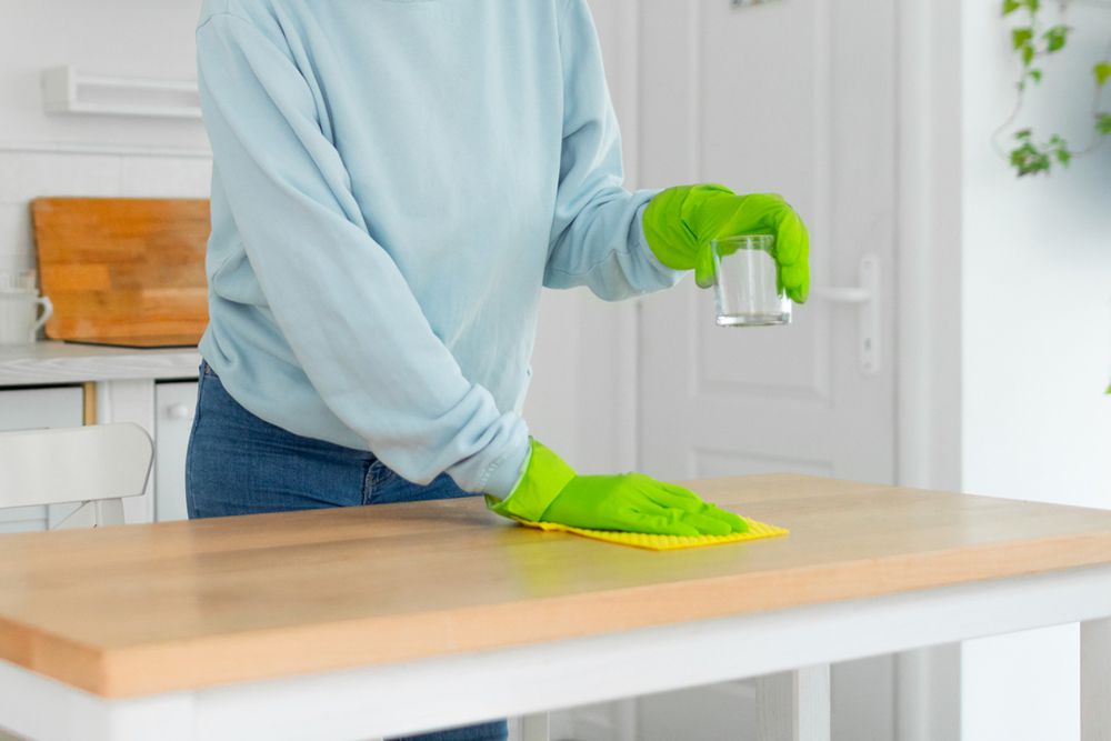 pessoa usando um pano de prato sueco para limpar uma ilha de cozinha