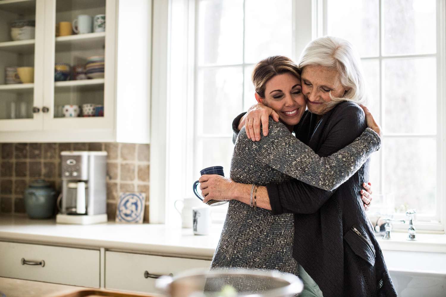 Zwei Frauen umarmen sich in der Küche