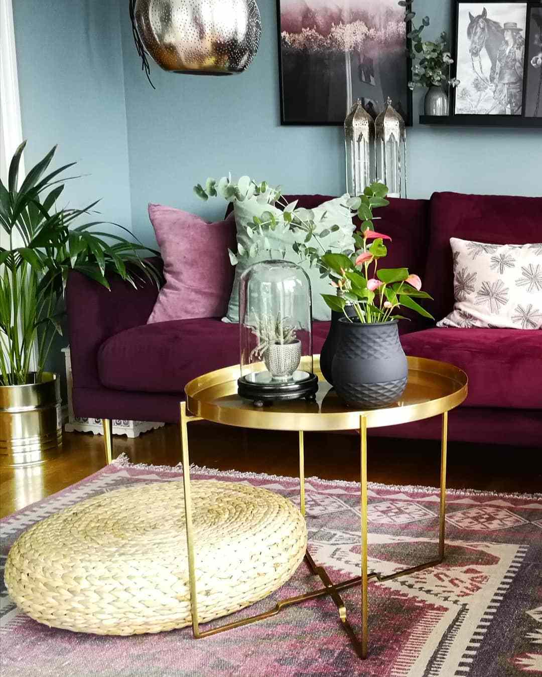 Wohnzimmer mit gedämpfter grüner Farbe und dunkelrosa Couch