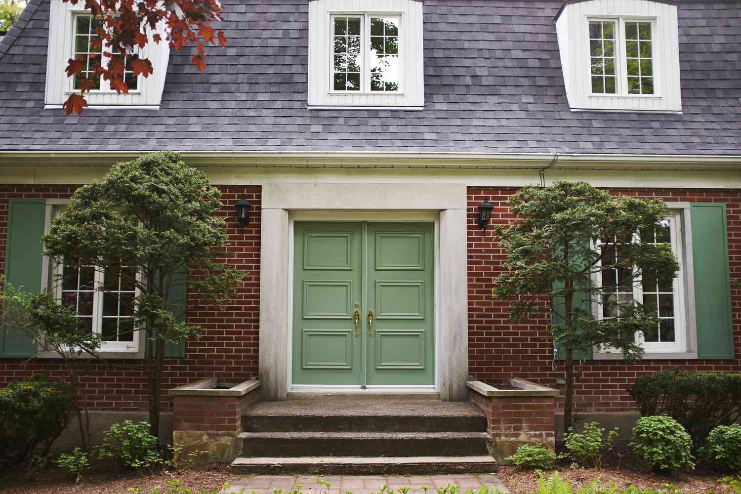 eine Hausfassade mit einer grünen Haustür