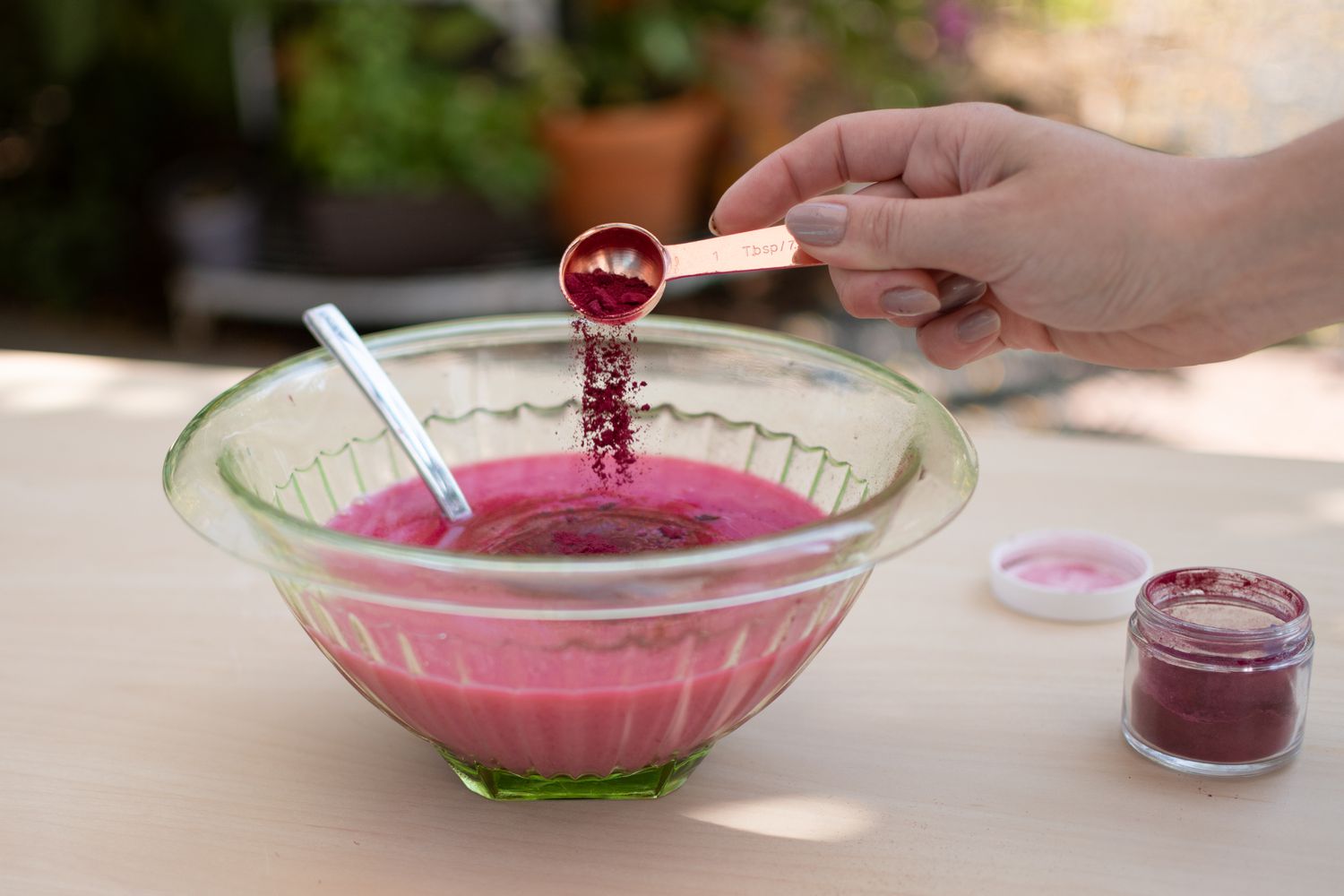 Rosafarbenes Pigment in einer Glasschale mit abgeseihter Milch und Zitrone