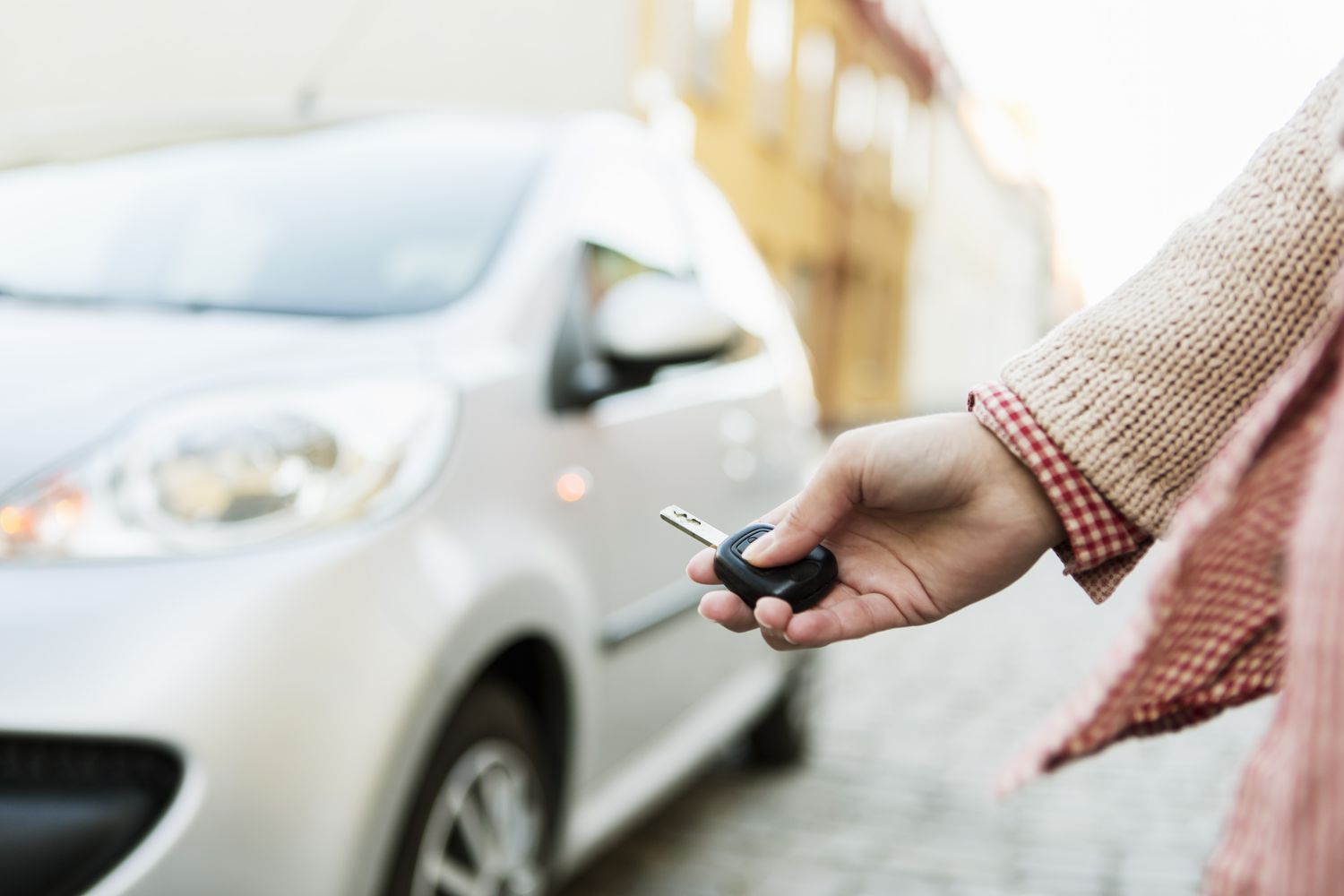 Cropped image of businesswoman using remote control key to unlock car