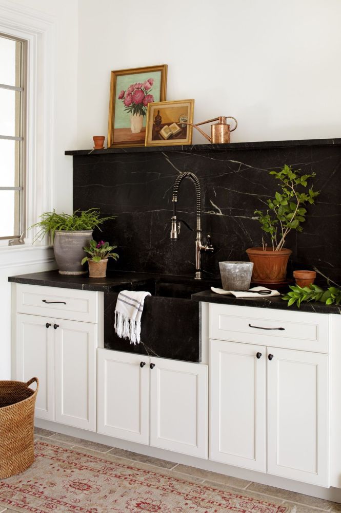 black marble backsplash and sink atop of white cabinetry