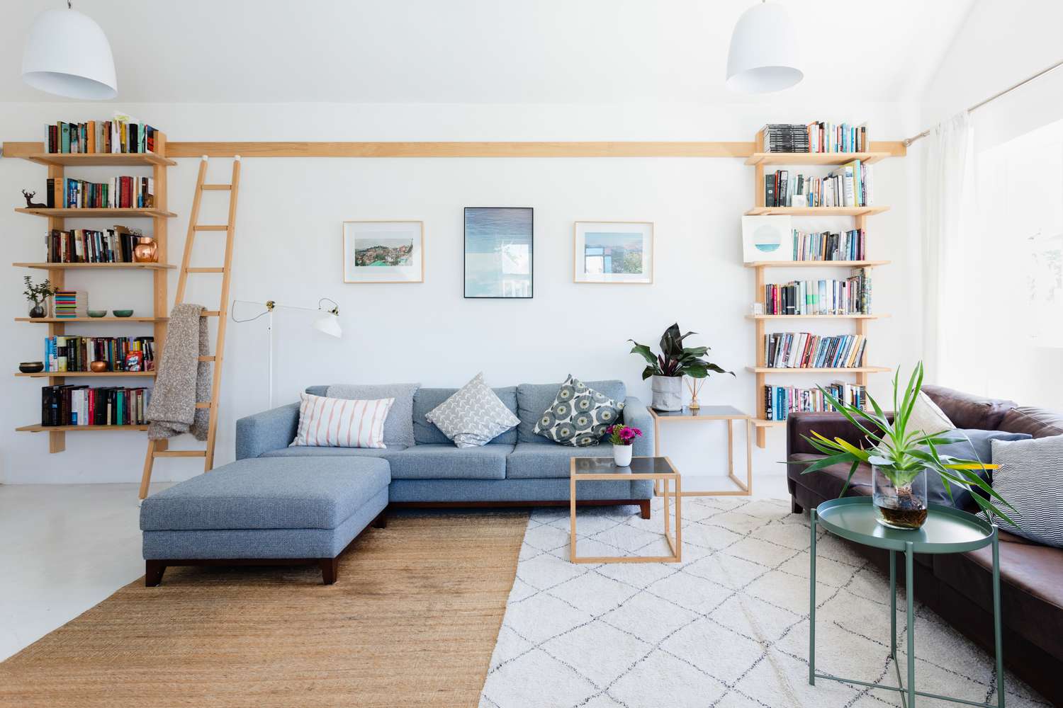 Hell erleuchtetes Wohnzimmer, dekoriert mit Bücherregalen und Kissen