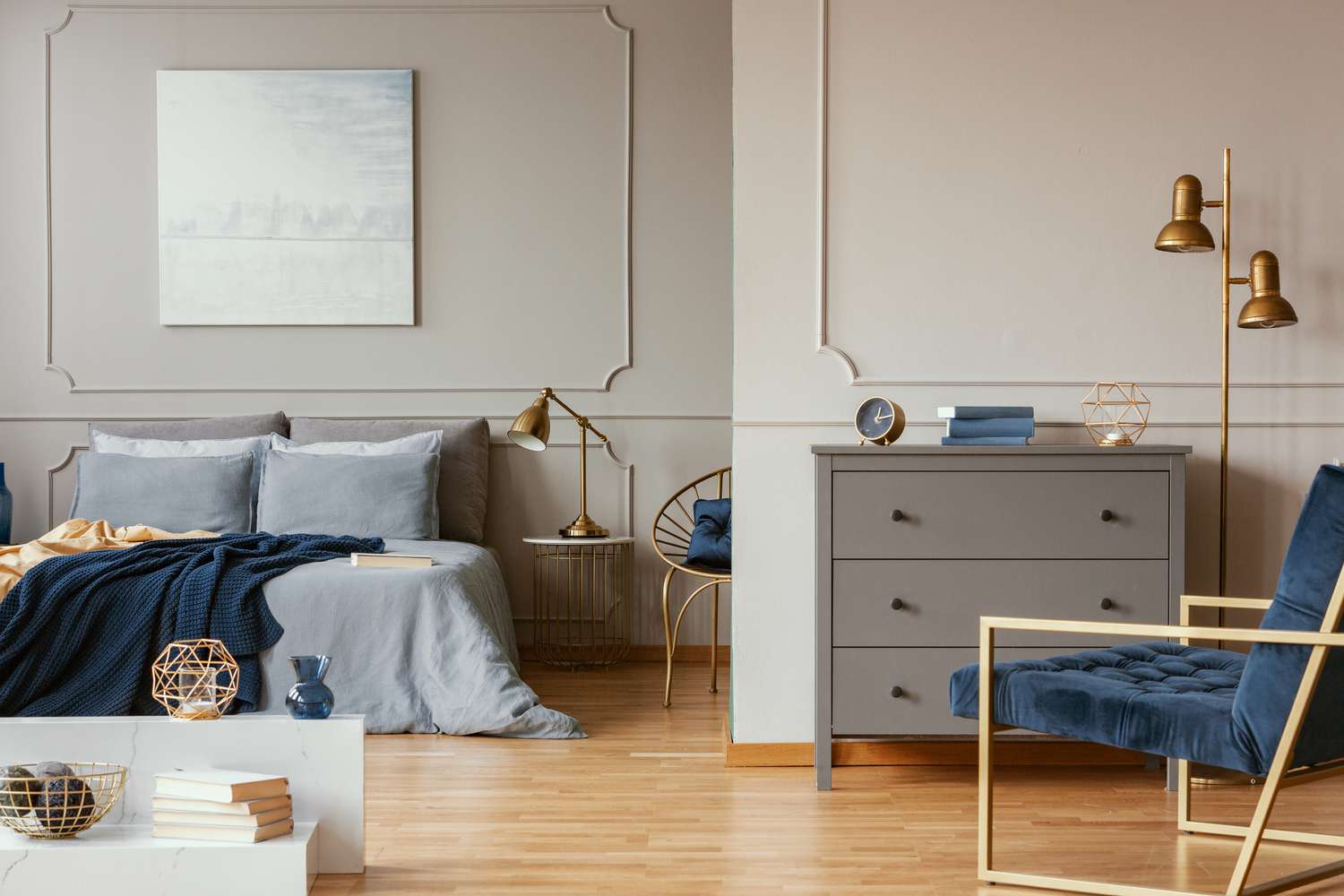 Pastellblaues abstraktes Gemälde über einem Kingsize-Bett in einem eleganten Schlafzimmer mit goldenen Akzenten