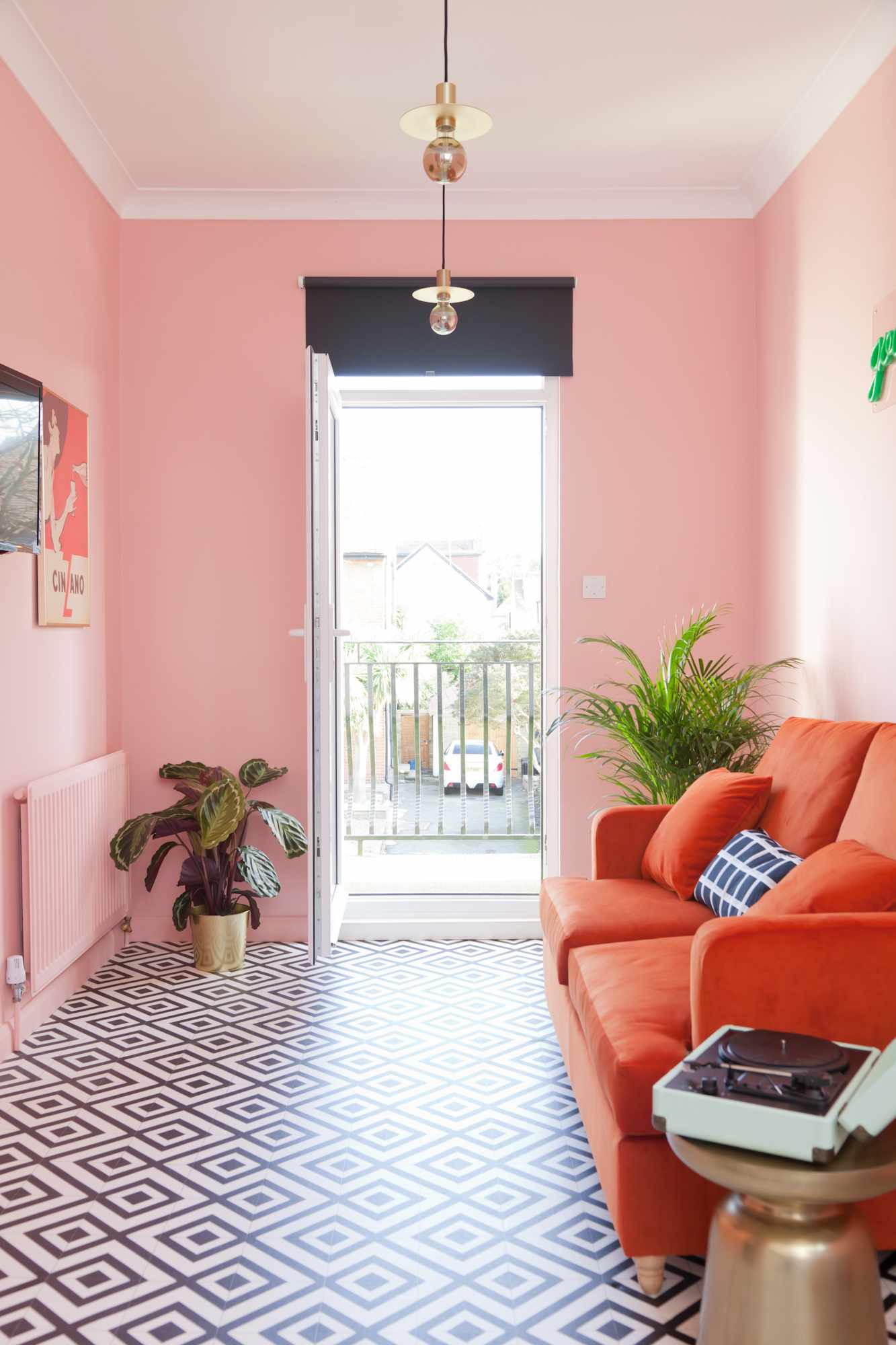 Habitación con paredes rosas y sofá rojo