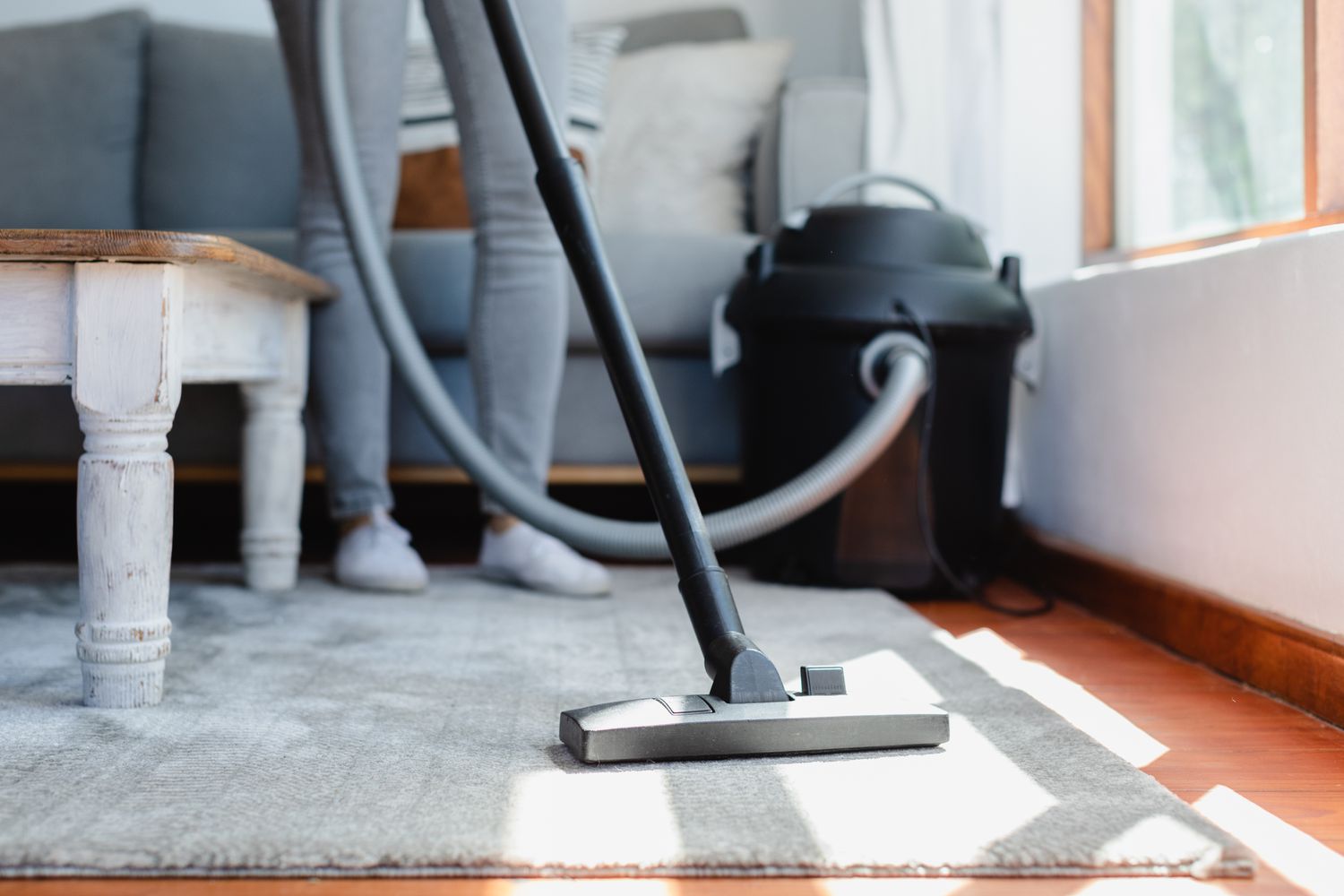 Upright vacuum cleaner vacuuming over carpet 