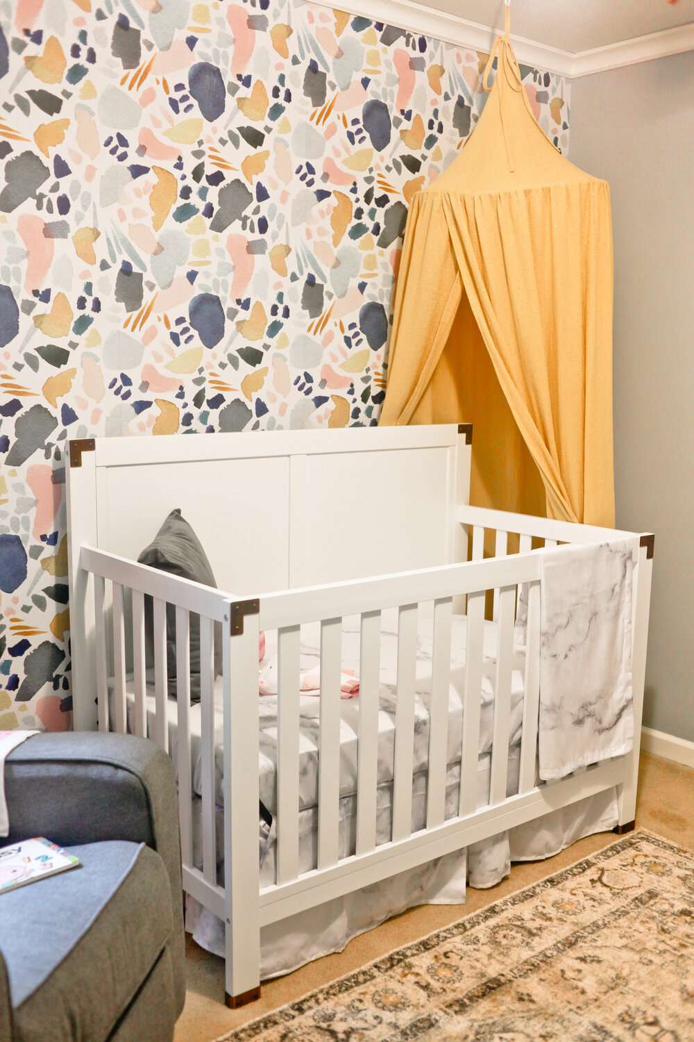 nursery with yellow, blue, olive green, and pink color scheme
