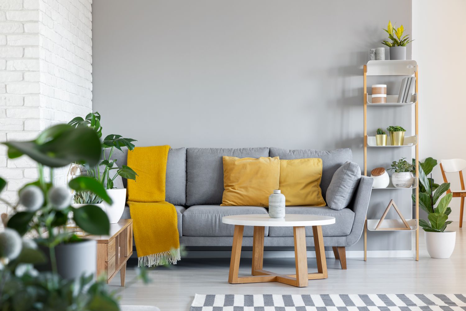 Coussins orange et couverture sur canapé gris dans l'intérieur du salon avec table en bois. Real photo