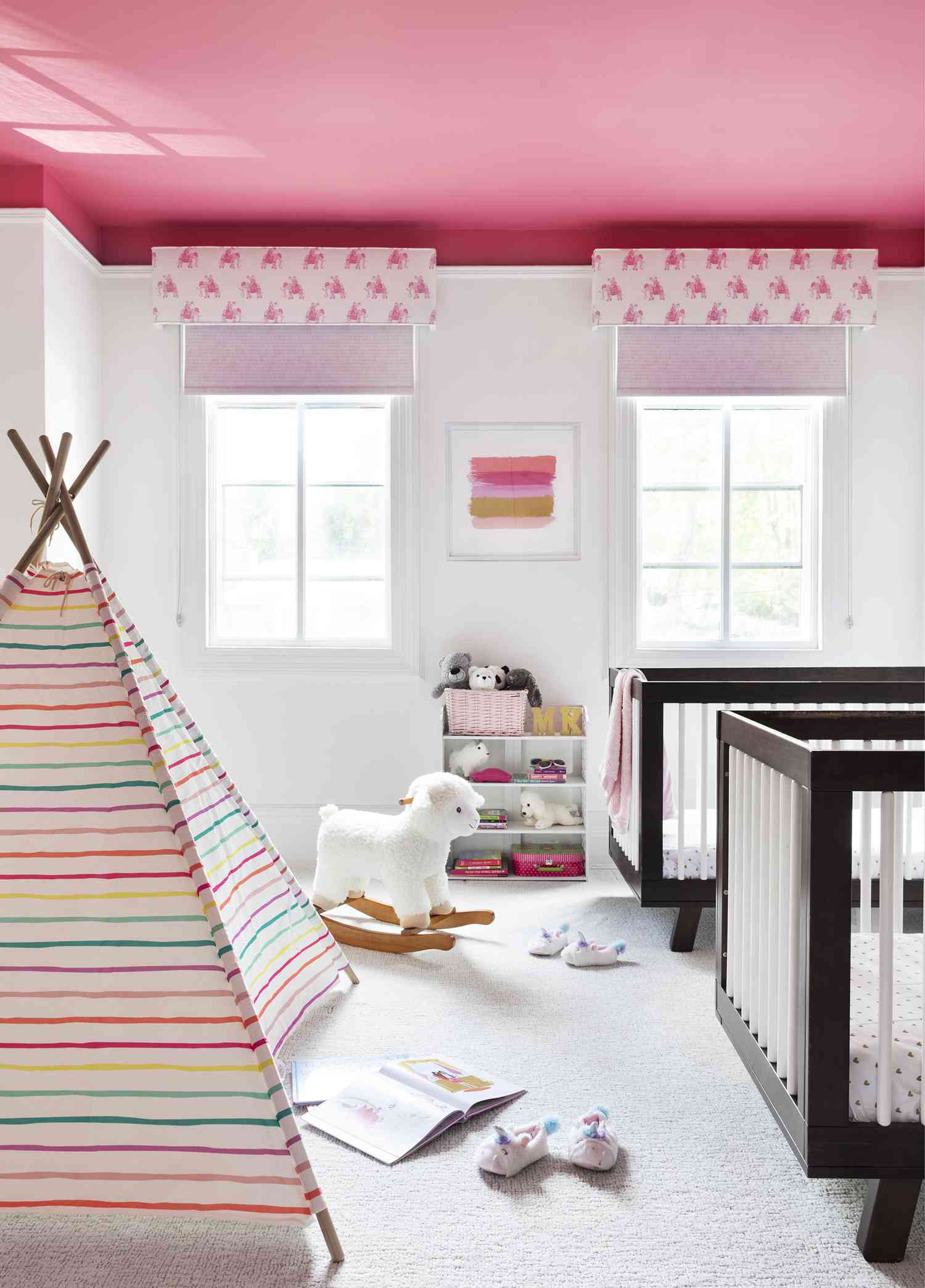 una habitación infantil presenta paredes blancas y techo rosa intenso