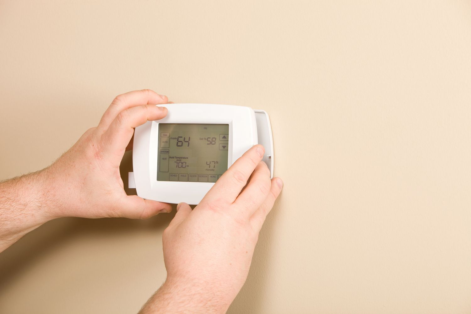 Mann, der einen programmierbaren Thermostat installiert