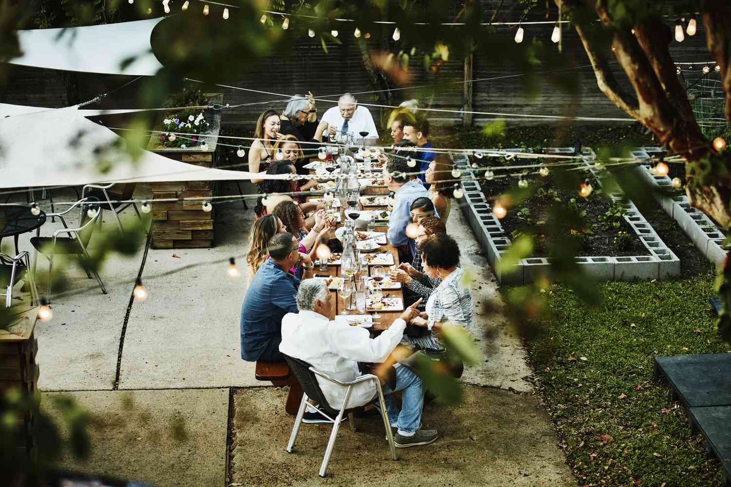 Vista aérea de la familia sentada junta en el patio exterior para la cena de celebración