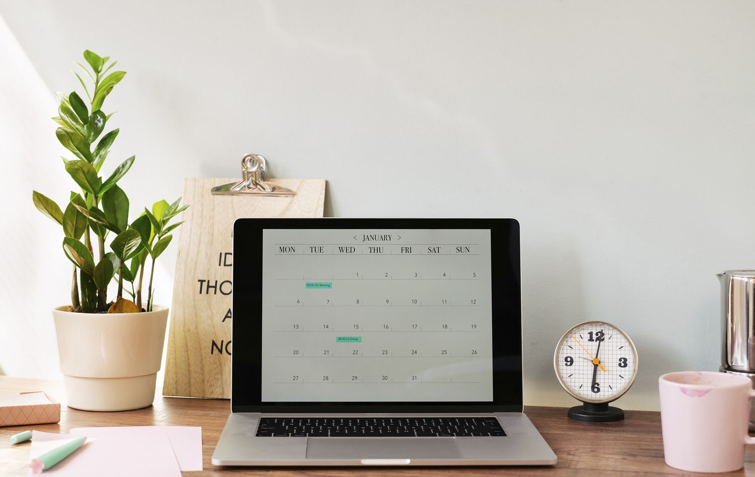 Portátil abierto con un calendario sobre el escritorio de la oficina en casa
