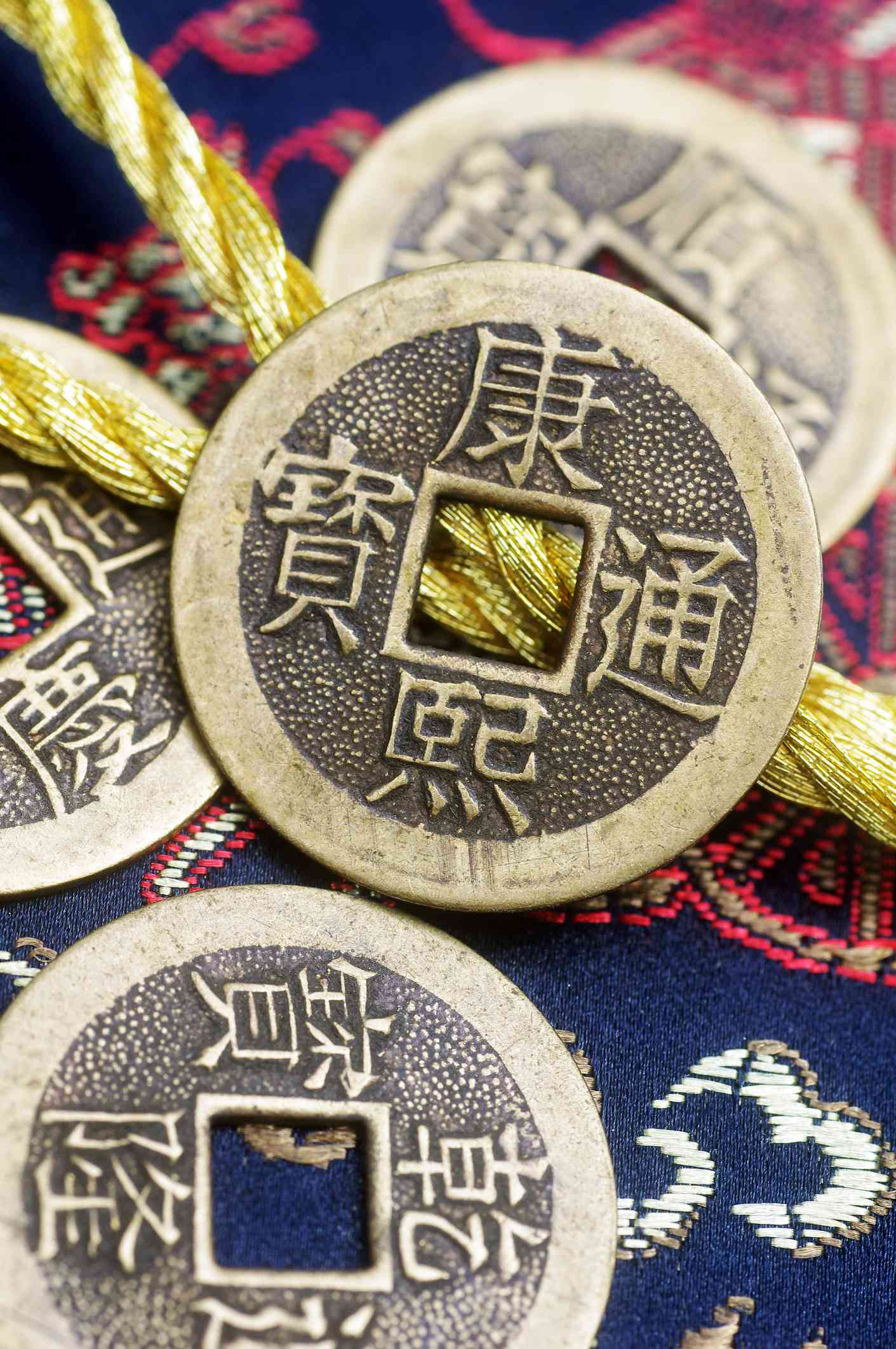 Alte chinesische Kupfermünzen auf gesticktem Stoff