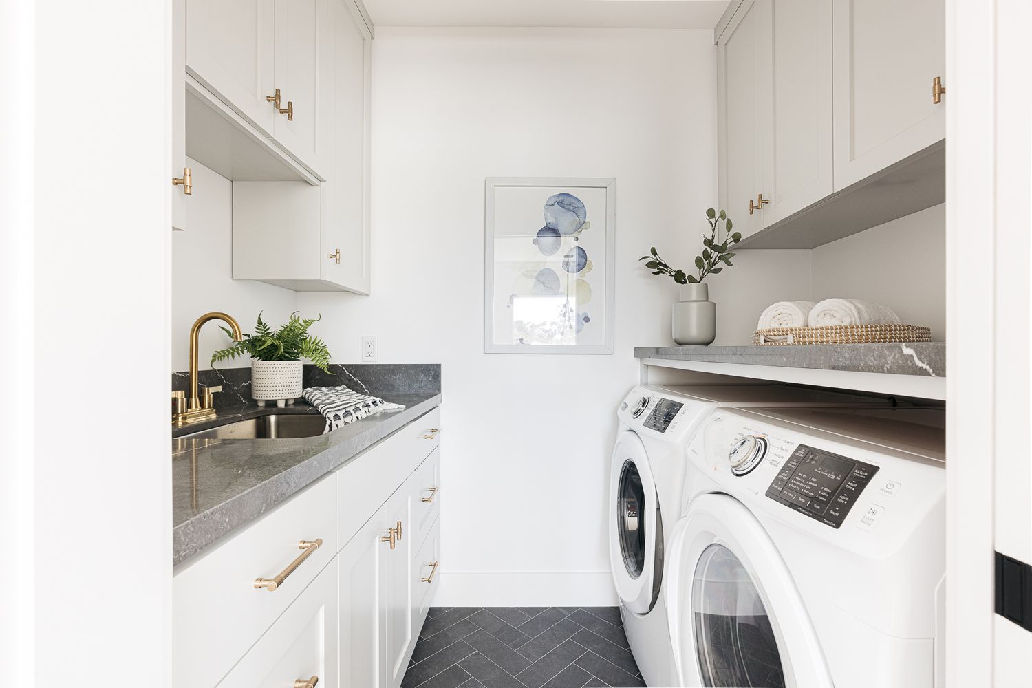 Waschküche mit weiß gestrichenen Wänden und Schränken