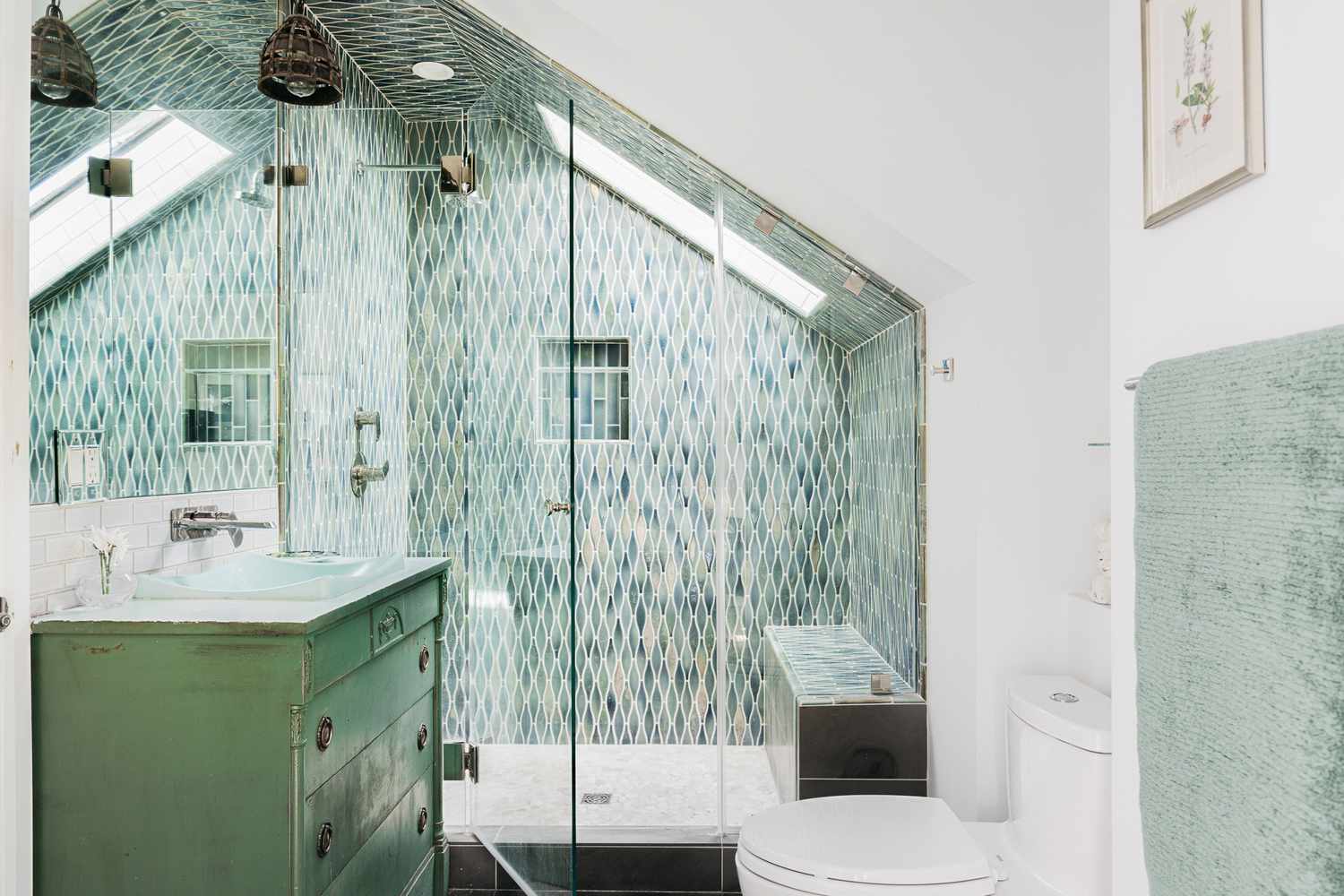 Soft mint green tiles in stand-in shower with skylight