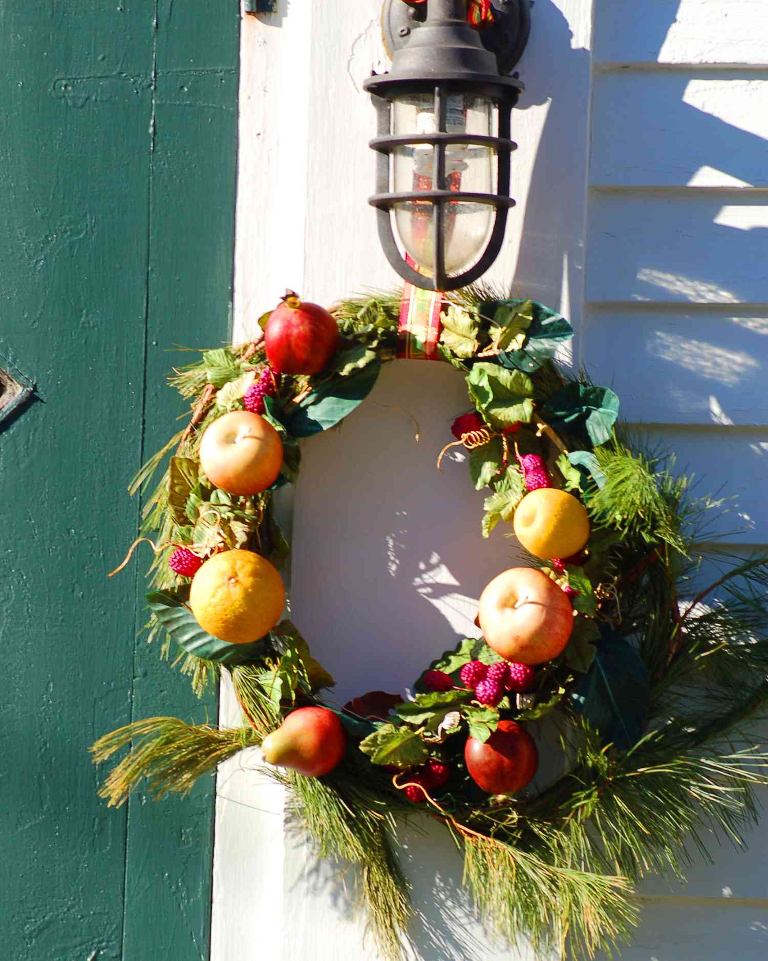 Der immergrüne Kranz auf diesem Foto ist mit Früchten geschmückt. Das ist ein schöner Weihnachtslook.