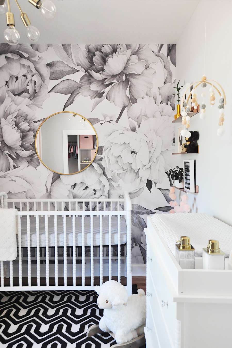 Quarto de bebê moderno em preto, branco e dourado com estampa floral gráfica