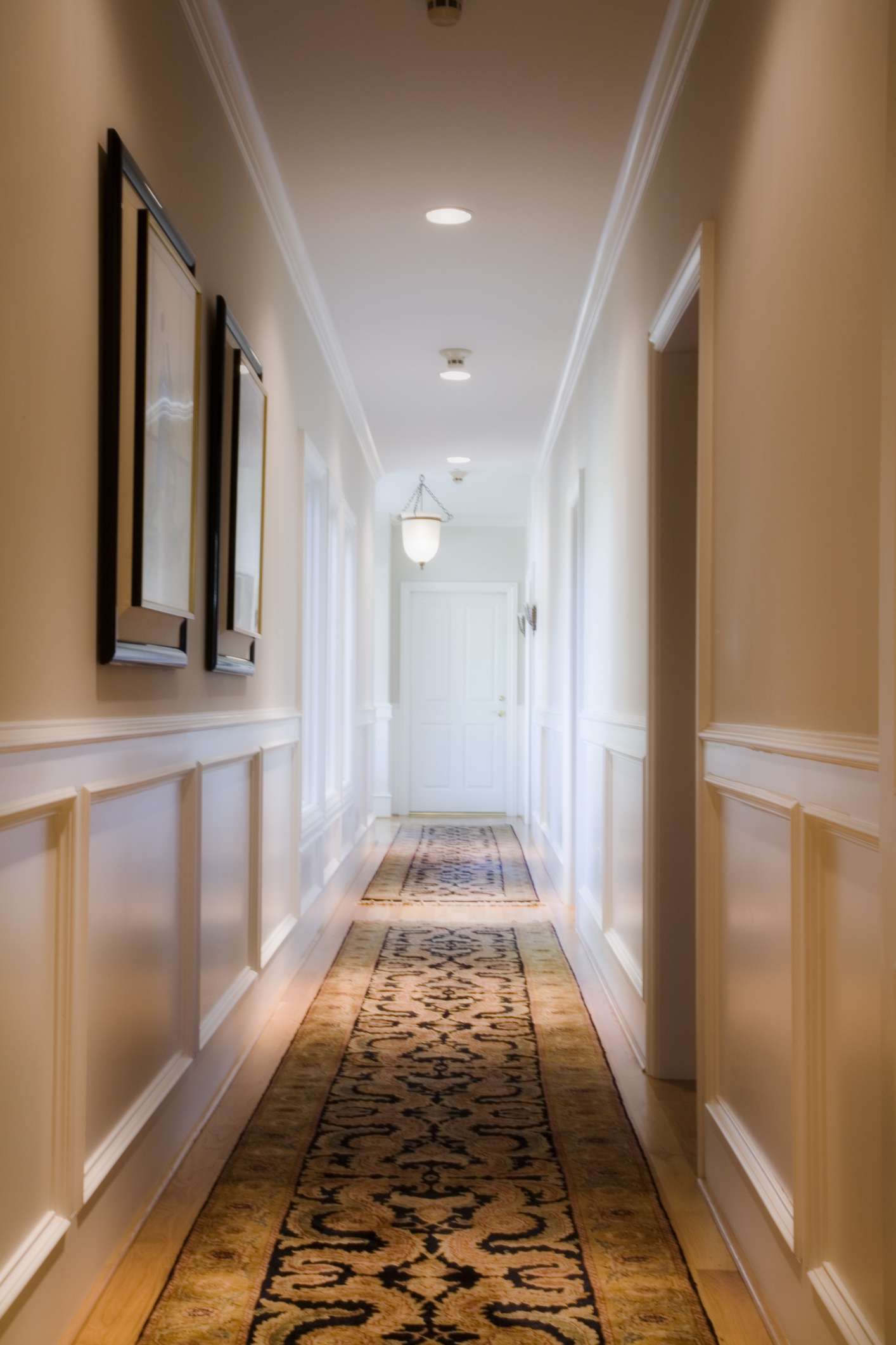 um longo corredor com arte e corredores no chão com iluminação