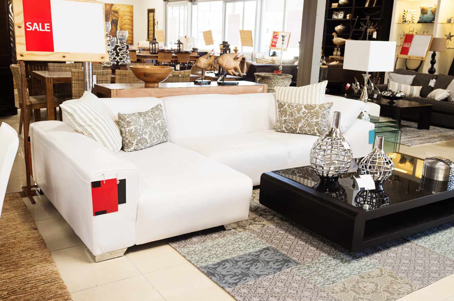 Ein schönes Möbelarrangement mit einer weißen Couch und einem Couchtisch in einem Möbelhaus.
