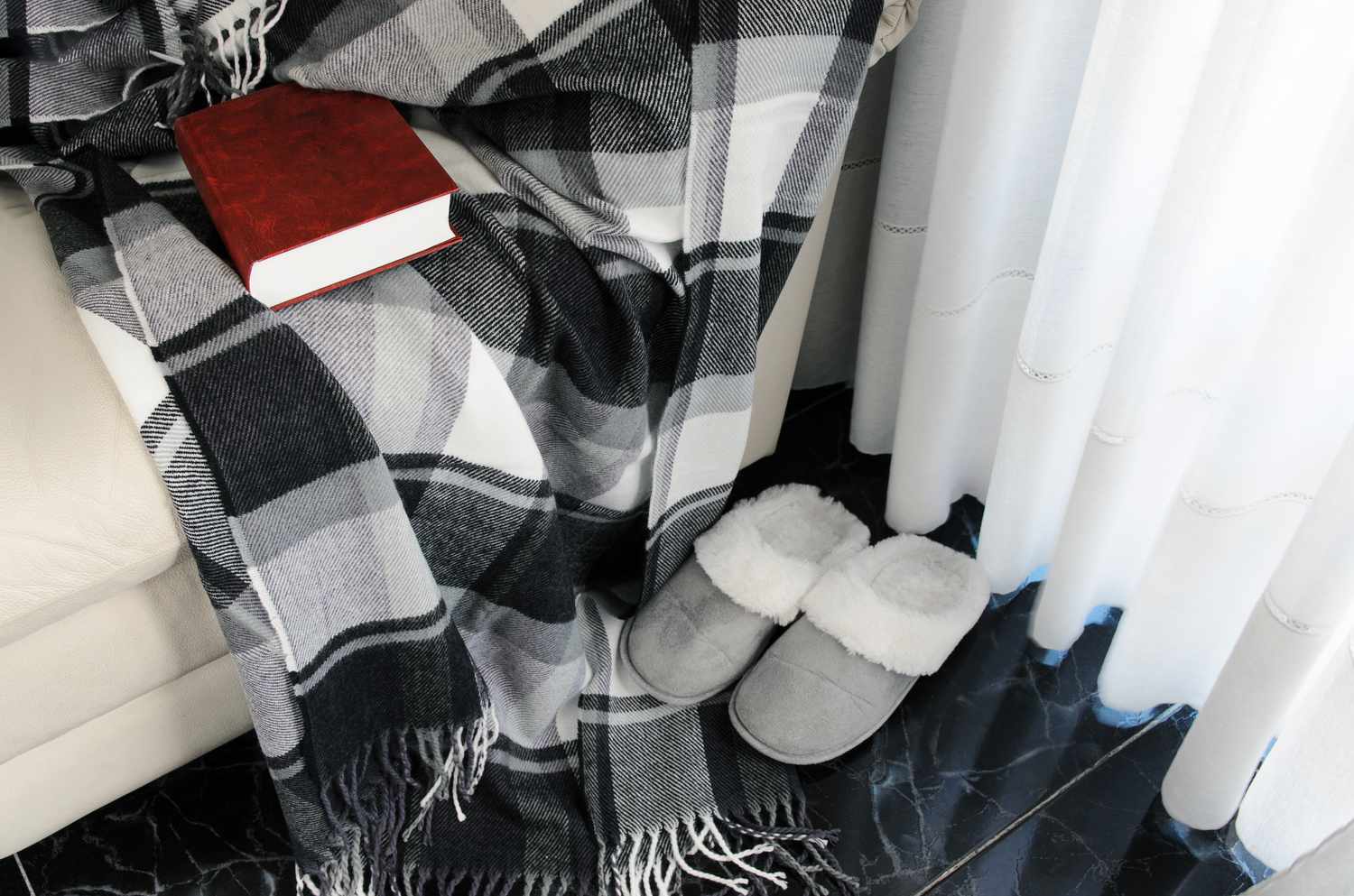 Karierte schwarz-weiß karierte Decke mit Hausschuhen