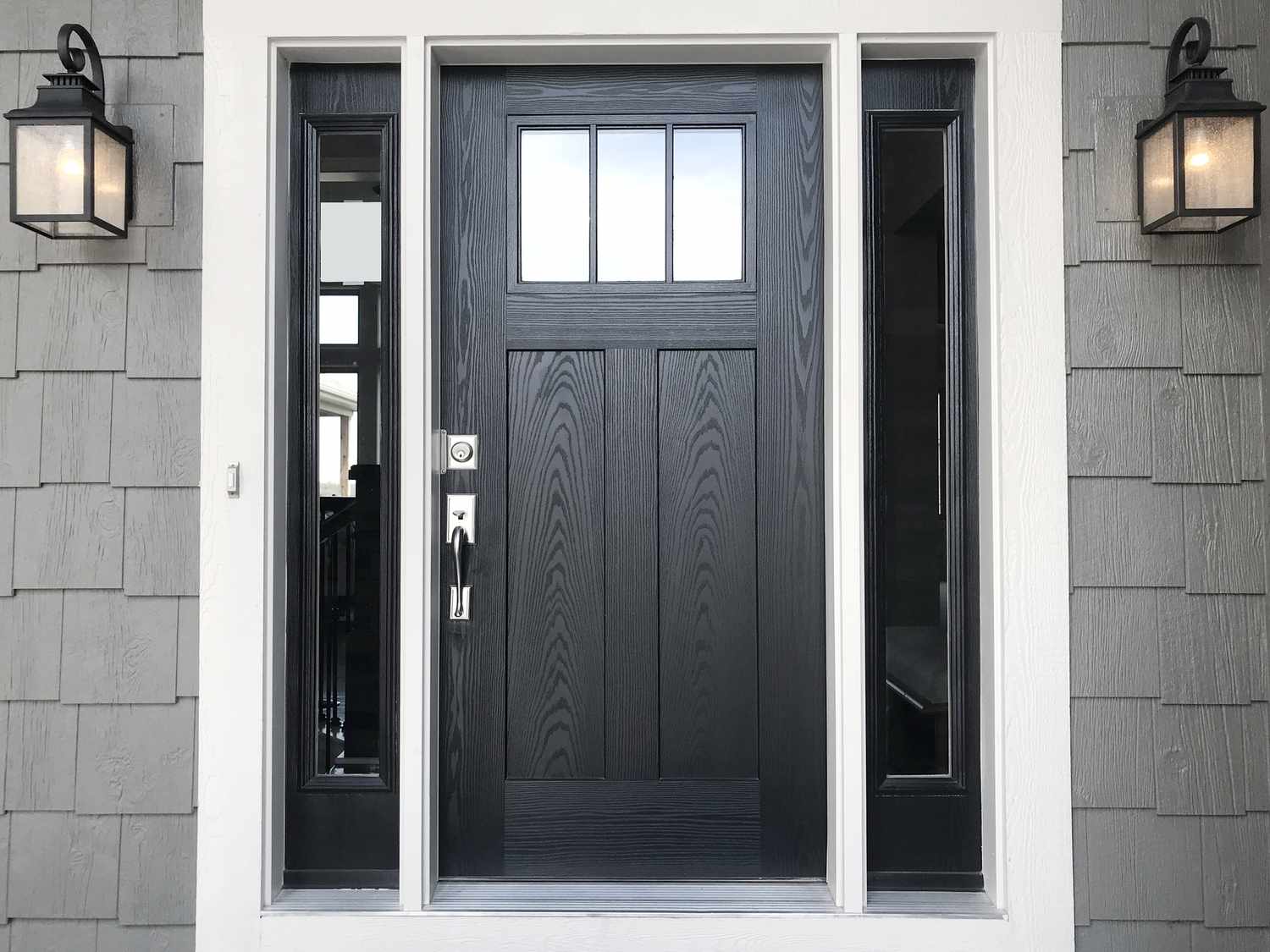schwarze Haustür mit grauen Wänden an einem Haus