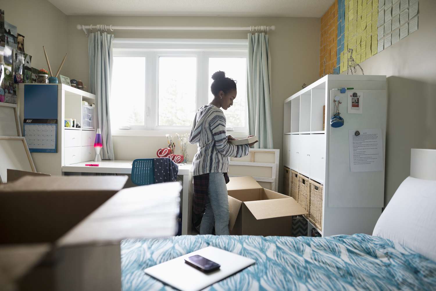 Teenager-Mädchen packt Schlafzimmer, bereitet sich aufs College vor