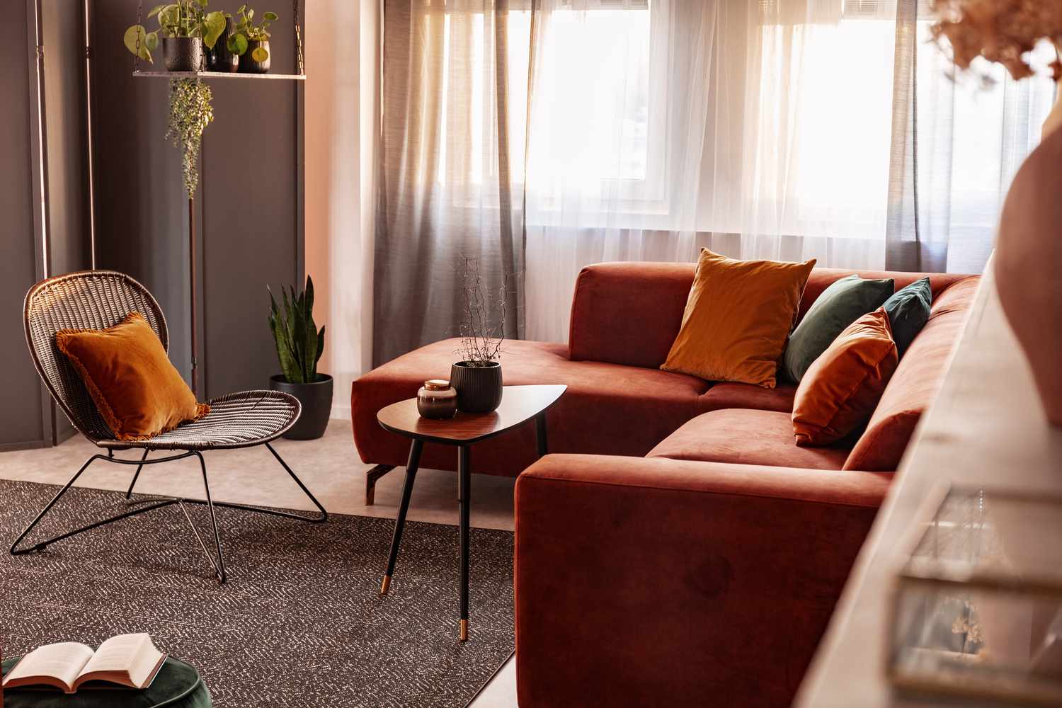 Pequena mesa de centro em frente a um confortável sofá de canto no interior de uma sala de estar com cores de outono