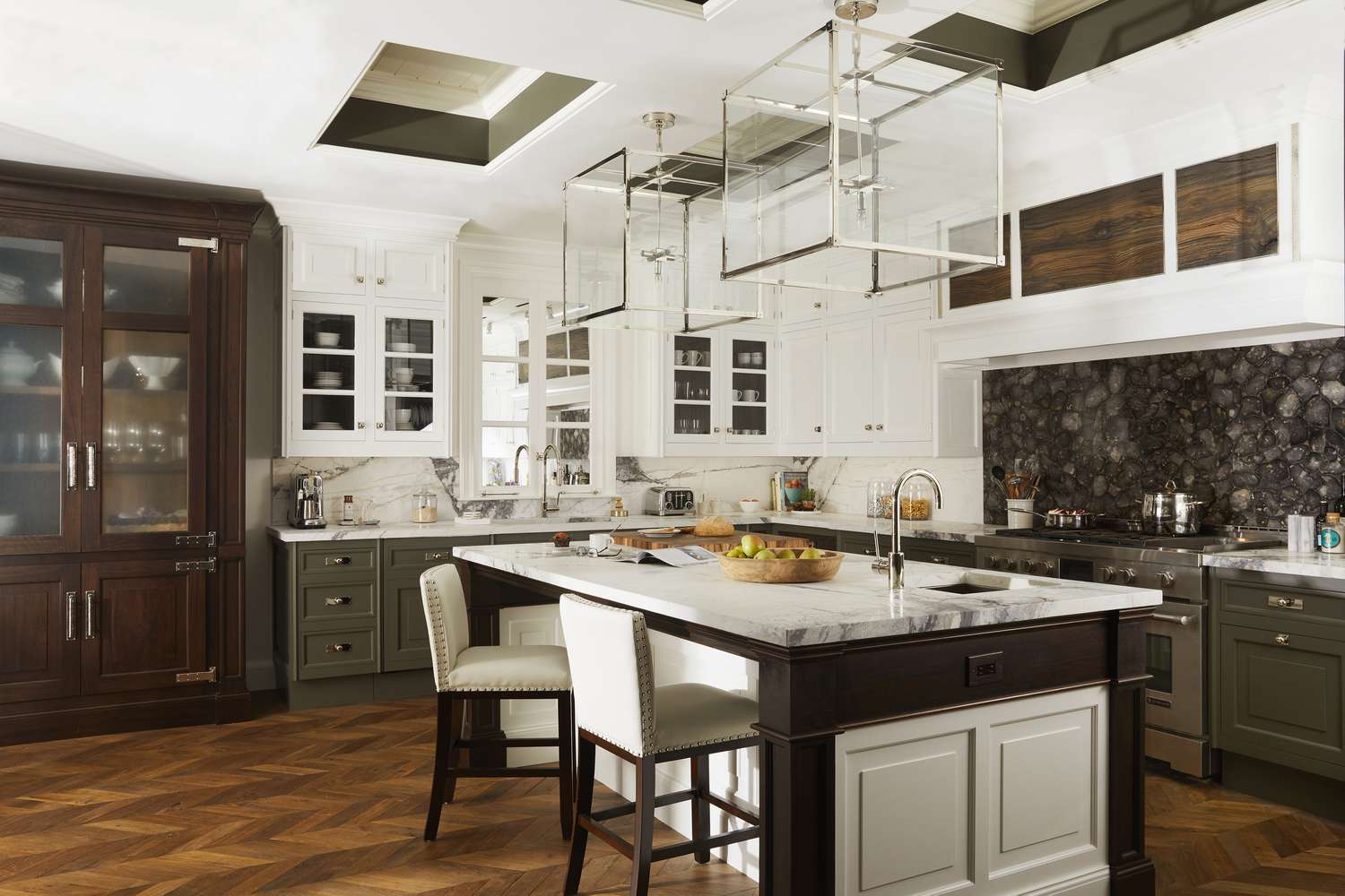 eine schöne Küche mit Holzboden, Marmorarbeitsplatte und weißen Schränken