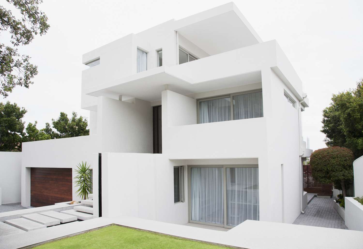 maison moderne avec extérieur blanc et porte de garage en bois brun