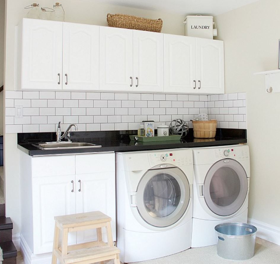 Laundry wall with subway tile backsplash and white cabinetry