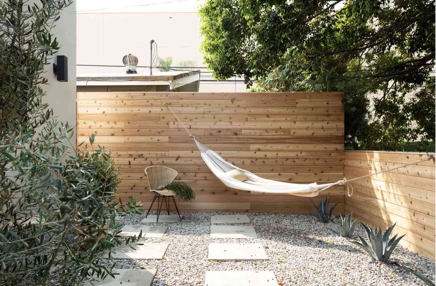 hammock setup in a backyard with pebble gravel