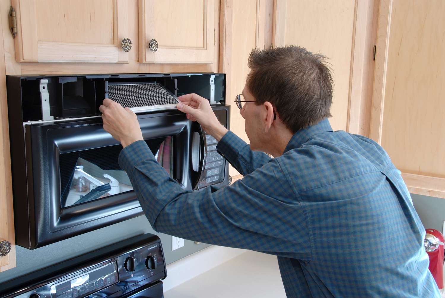 Homem consertando seu próprio micro-ondas