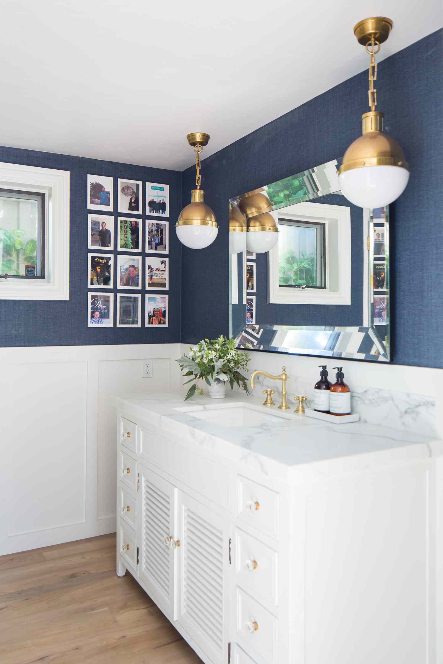 salle de bain bleu nautique et blanc avec lumières en laiton