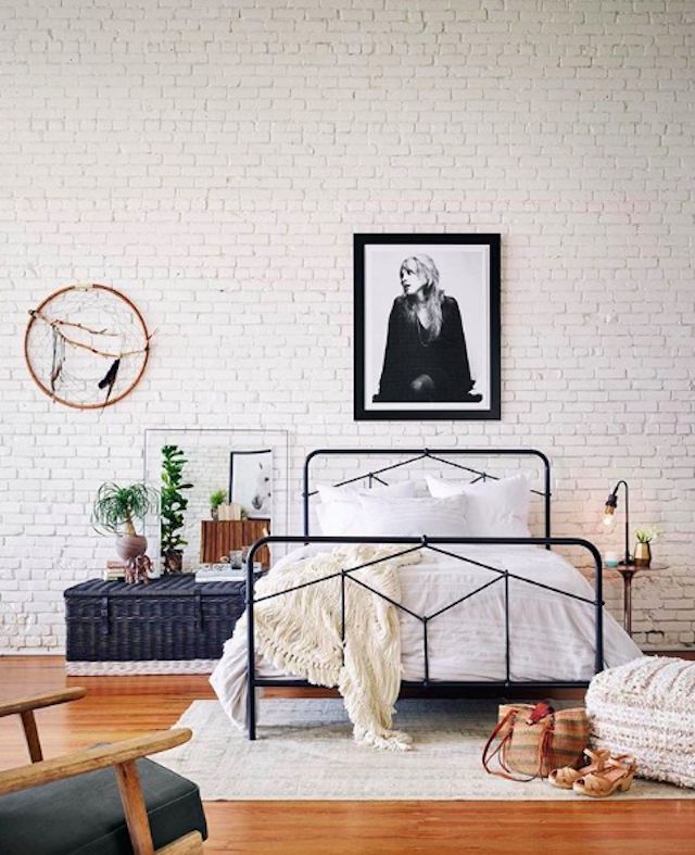 Schlafzimmer mit weißen Wänden und schwarzem Rahmenbett